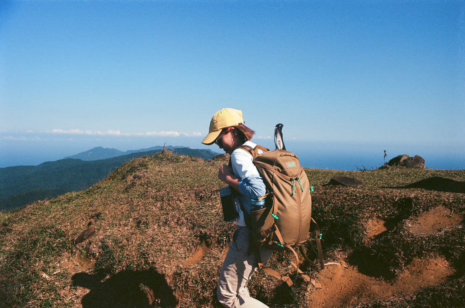 Lucy Chen hiking on a ridge above the coast